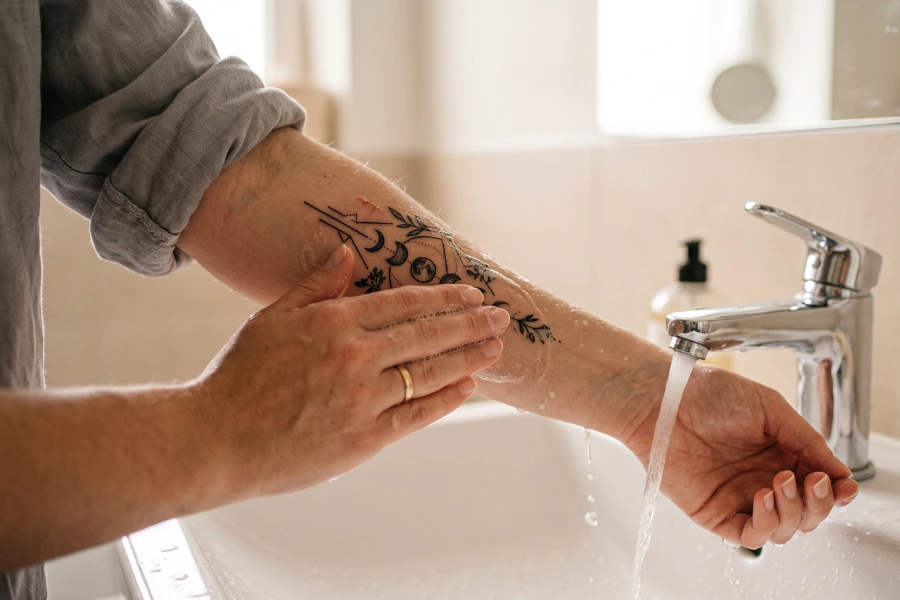 Fresh tattoo cleaning during first 48 hours - proper aftercare technique